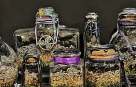 Protection spell jars: a group of dark jars with purple ribbon