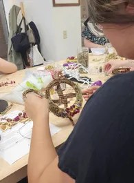 A guest wiring a grapevine wreath